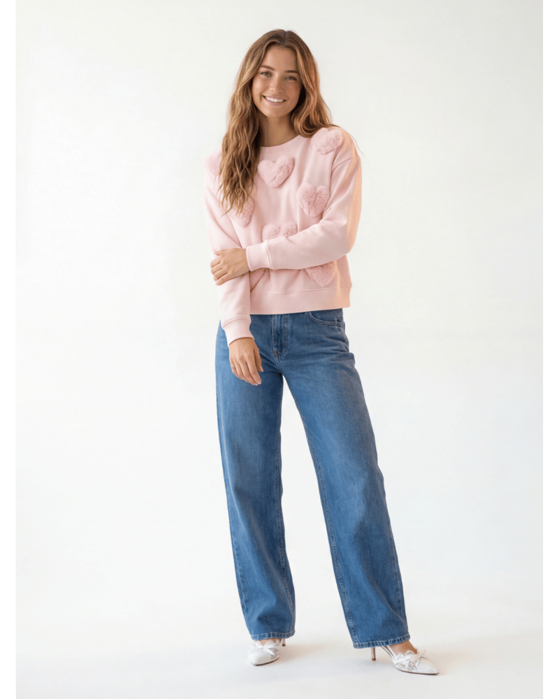 KI-Model trägt rosa Herz-Pullover — Frontansicht Pose 1